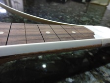 The fretboard needs to be narrower than the neck to account for the white edging.